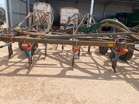 Agricultural tool with hoses and metal frame parked in a farm shed