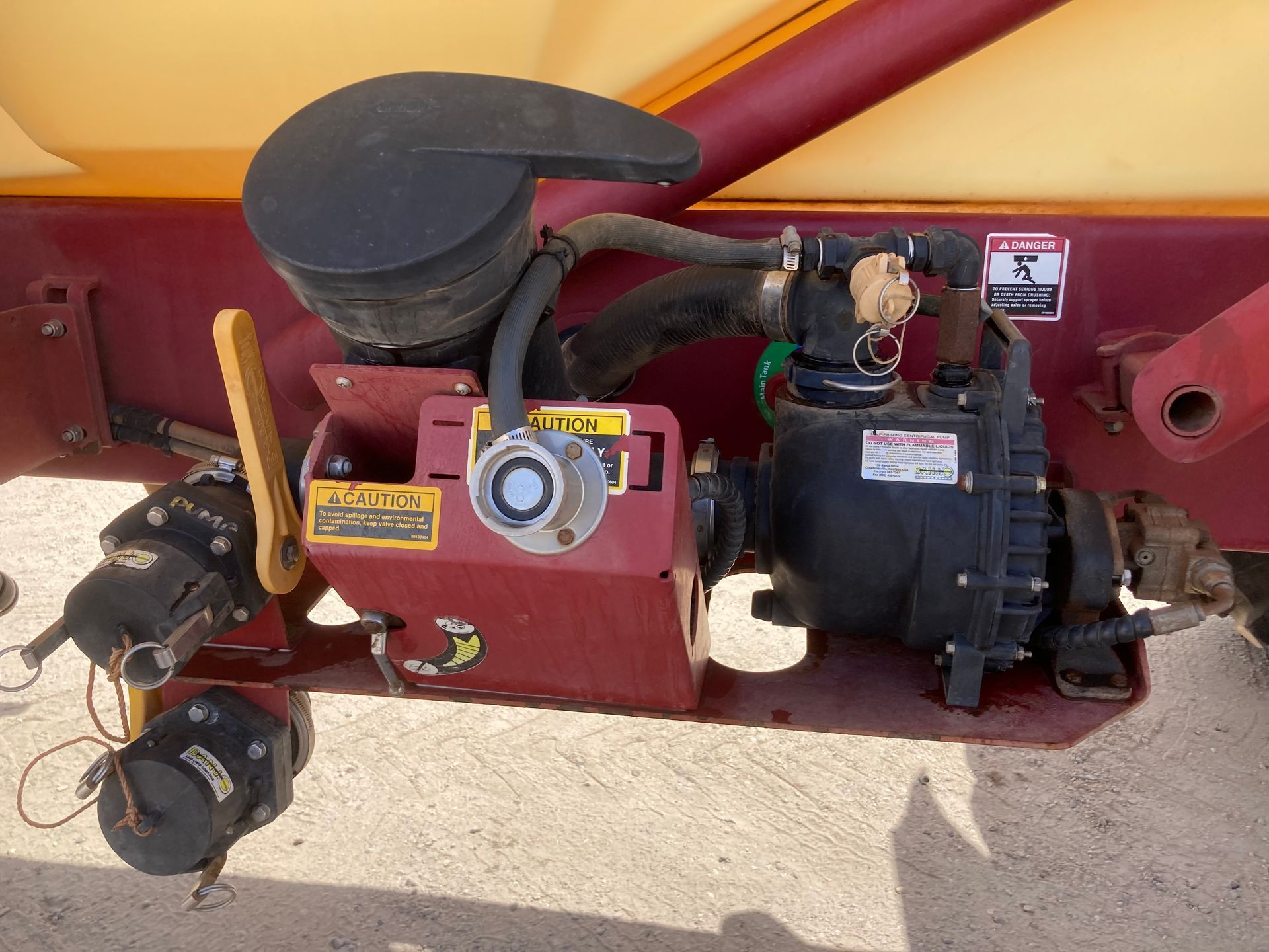 Close-up of a red and black pump or motor assembly mounted on industrial equipment.
