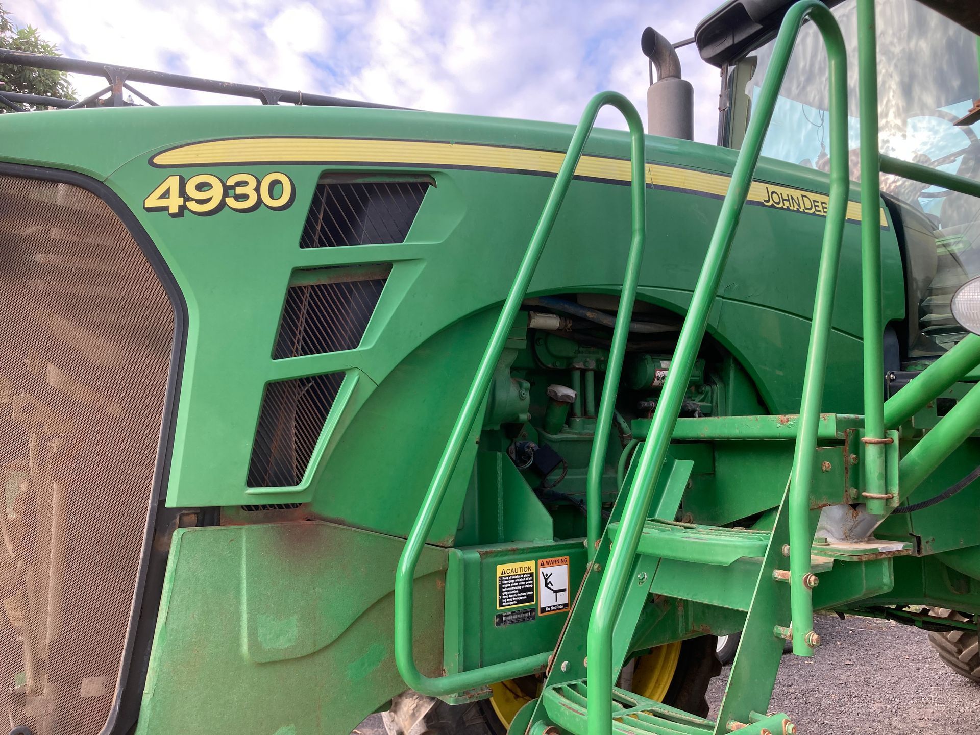Close-up of a green John Deere 4930 tractor front with large tire and cab steps