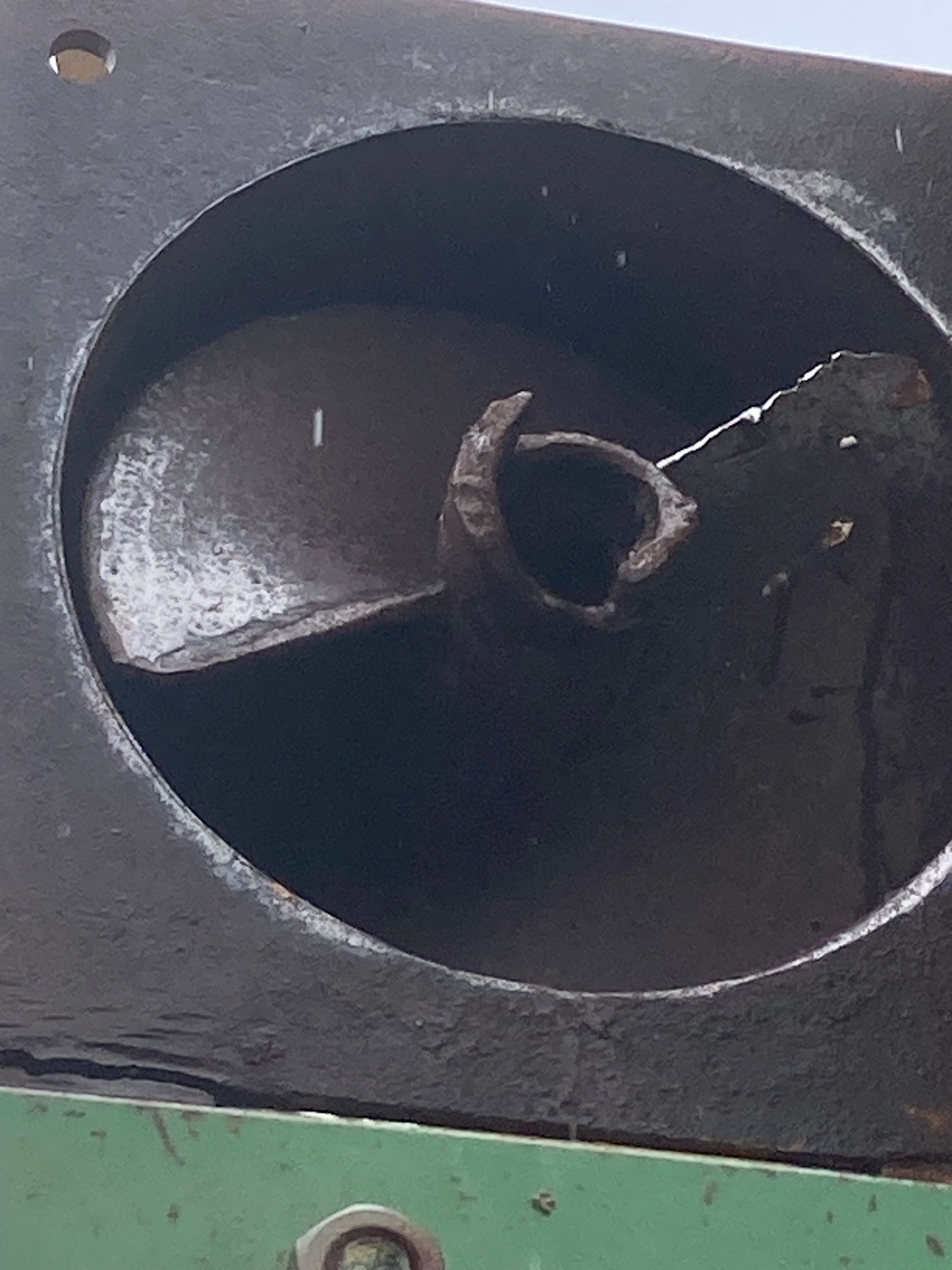 Close-up of a black speaker cone with a torn center and green panel below