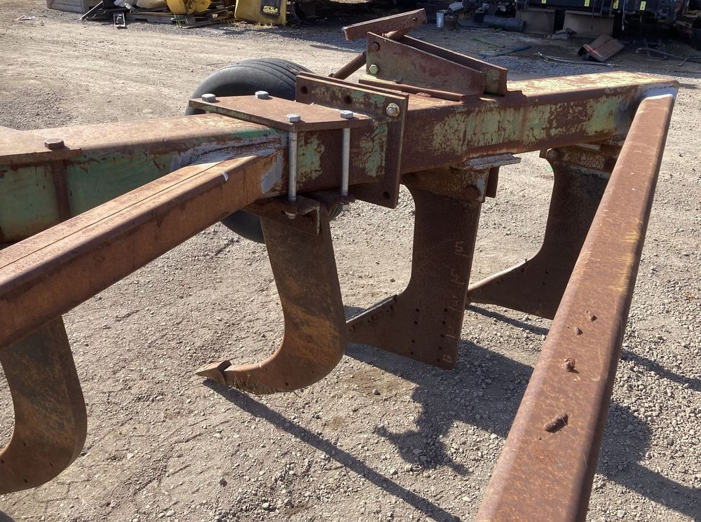 Rusty agricultural tillage implement with two tines on a dirt lot