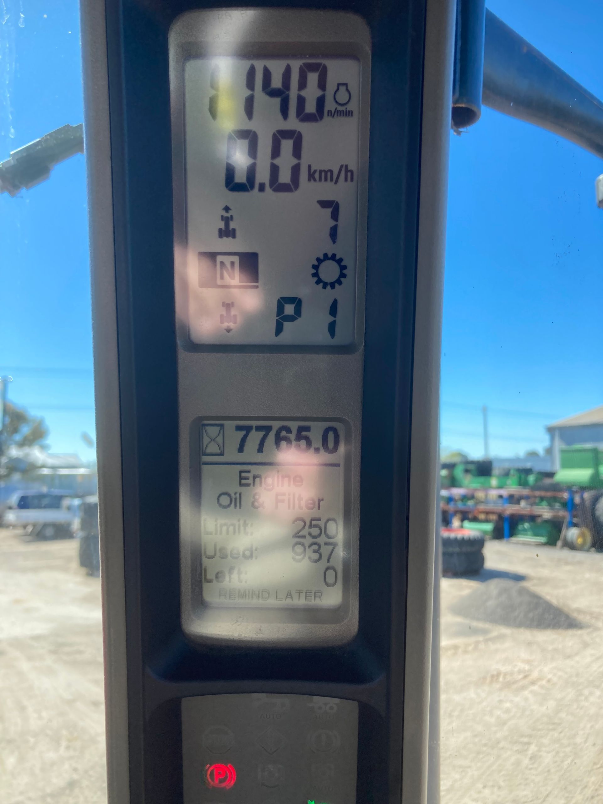 Close-up of a digital meter display on a sunny outdoor worksite, showing 14.0 and 0.0 km/h.