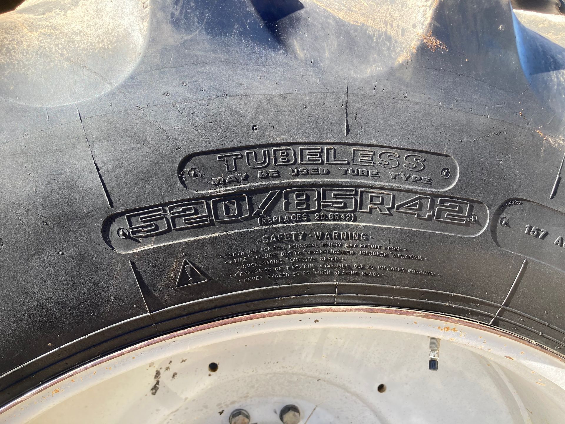 Close-up of a black tire sidewall with raised lettering above a white wheel rim.