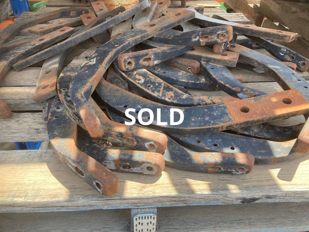Pile of rusted metal brackets on a wooden pallet with a white “SOLD” label