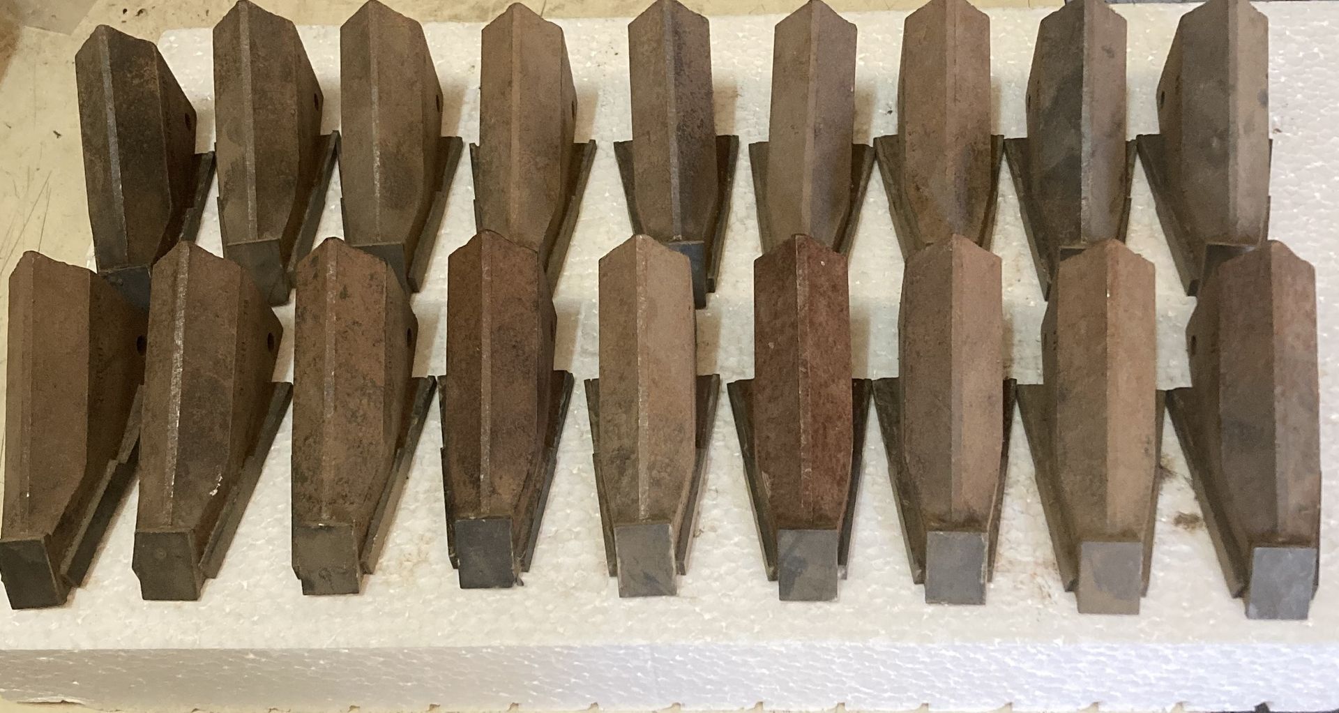 Close-up of a row of brown wooden clothespins on a white surface