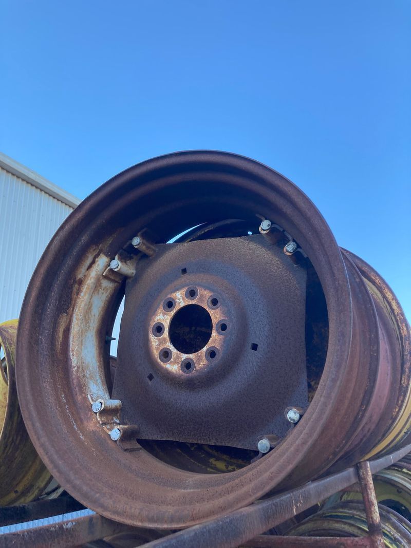 Close-up of a rusted metal wheel or pulley against a blue sky.
