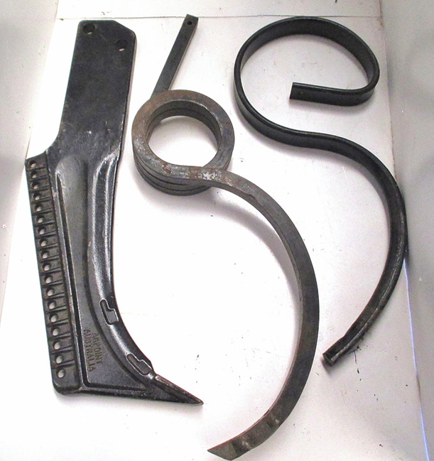 Three black metal hooks and blades arranged on a white background