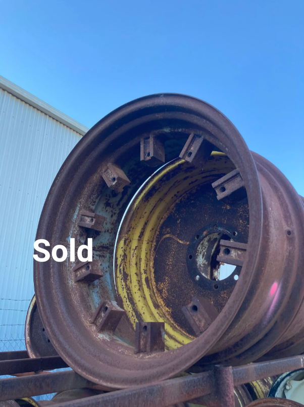 Rusty industrial wheel rim in a scrapyard, with “Sold” text overlaid.