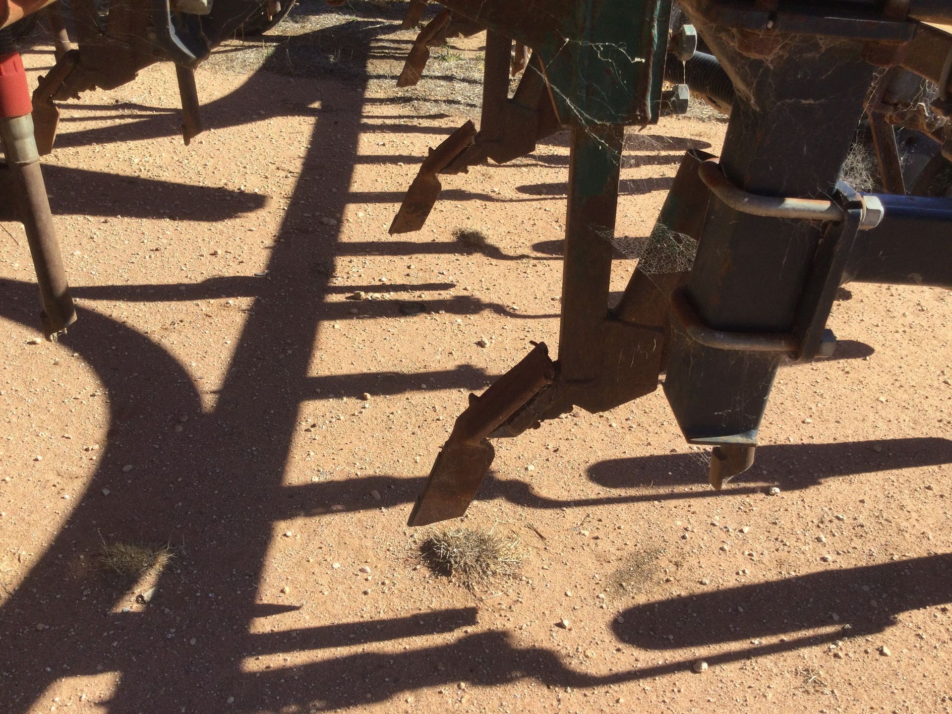 Shadows of playground equipment on sandy ground in bright sunlight