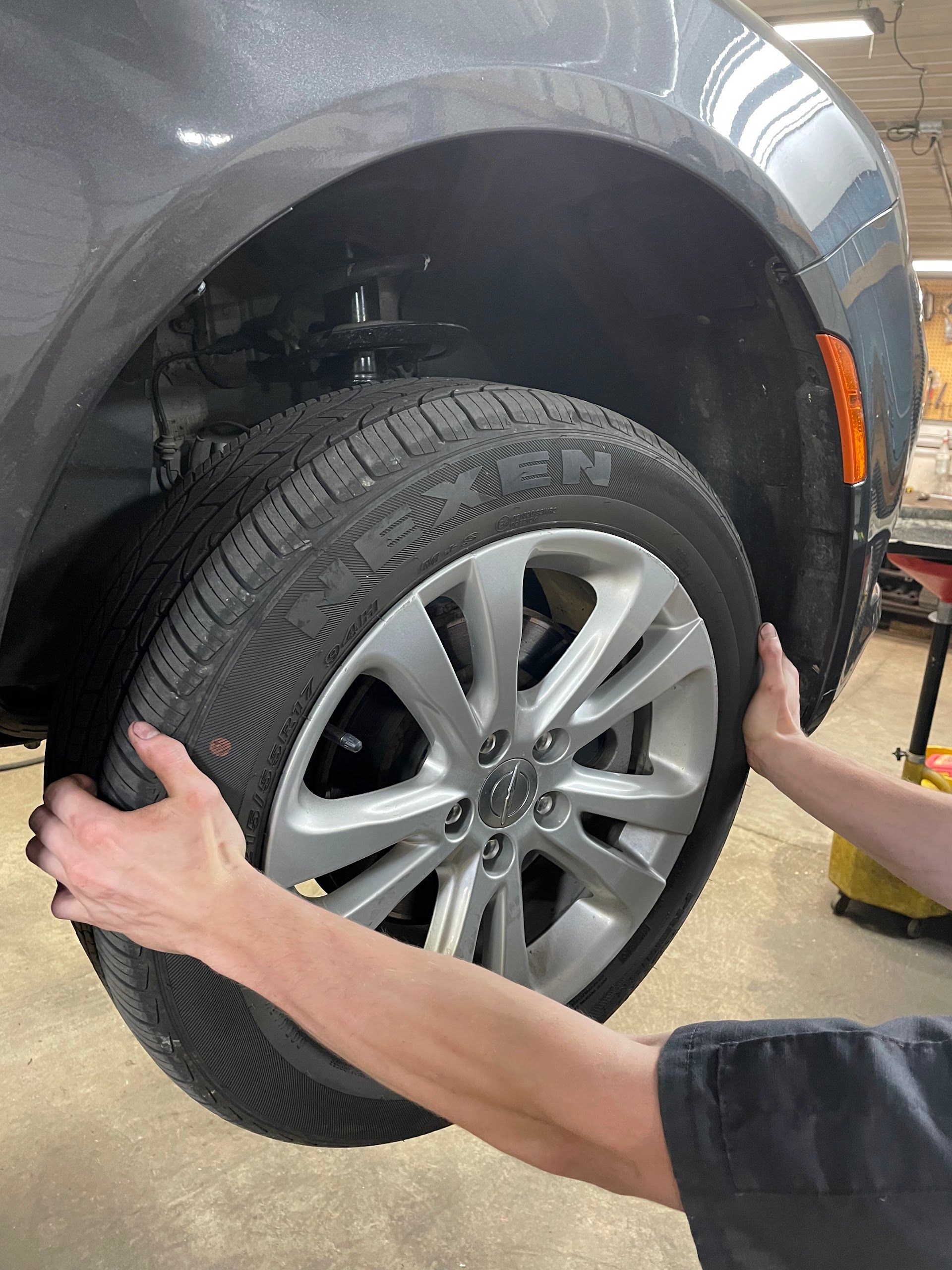 A Person Is Changing a Tire on a Car in a Garage | Dan's Auto Centre