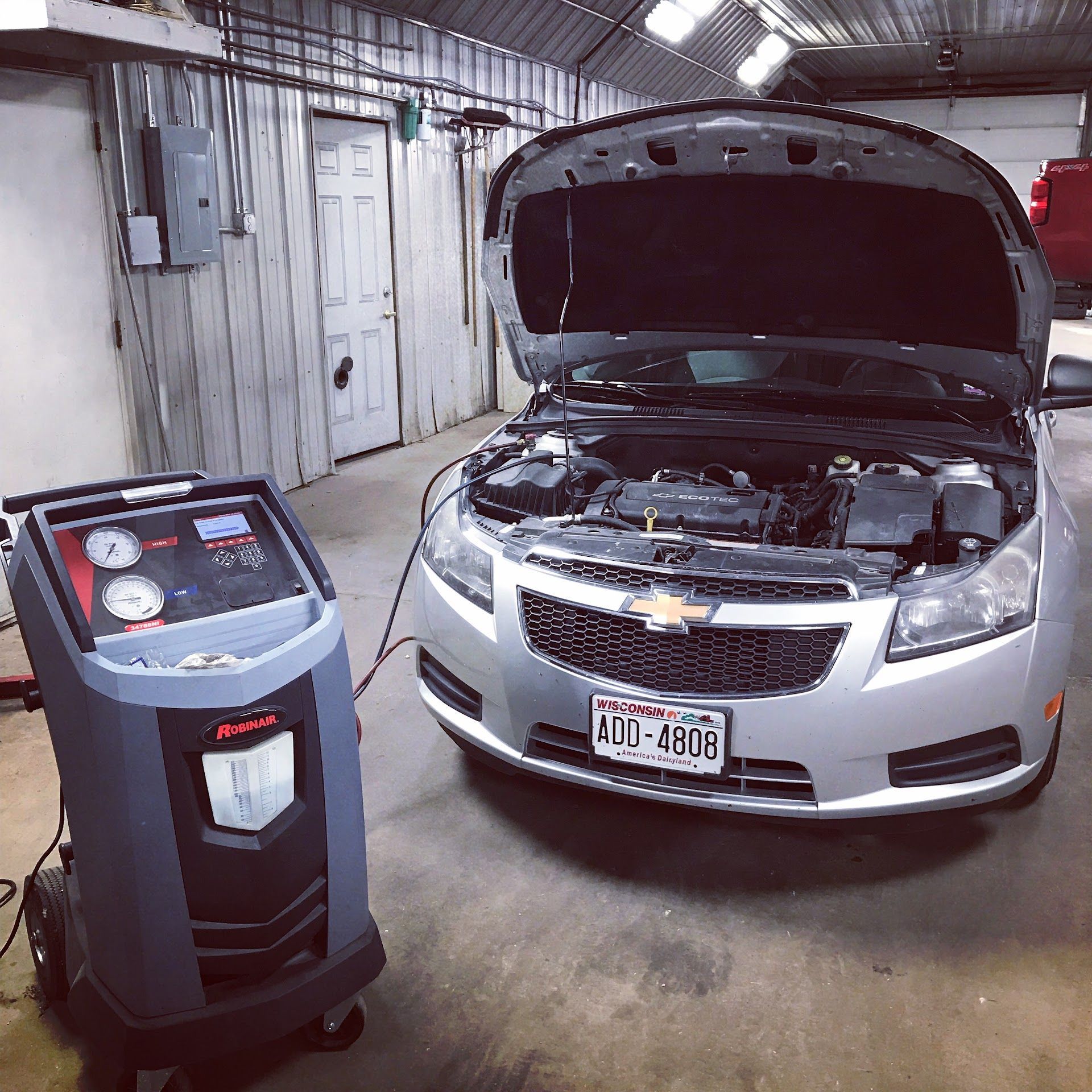 A Silver Car With the Hood Open Is Being Serviced in a Garage | Dan's Auto Centre