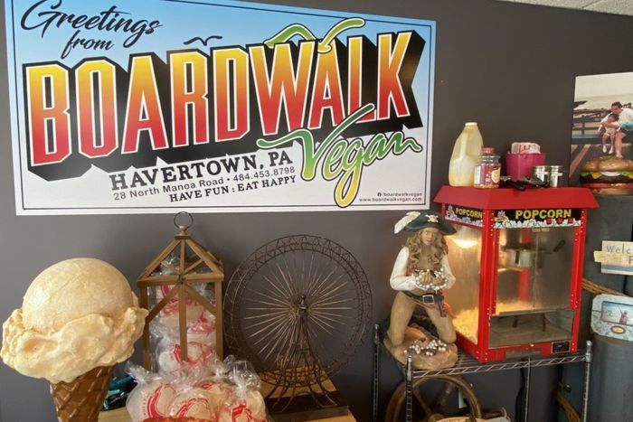 A sign that says greetings from boardwalk hangs on a wall
