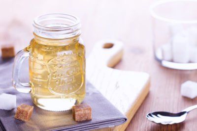 A mason jar filled with liquid organic sugar sitting on top of a book.