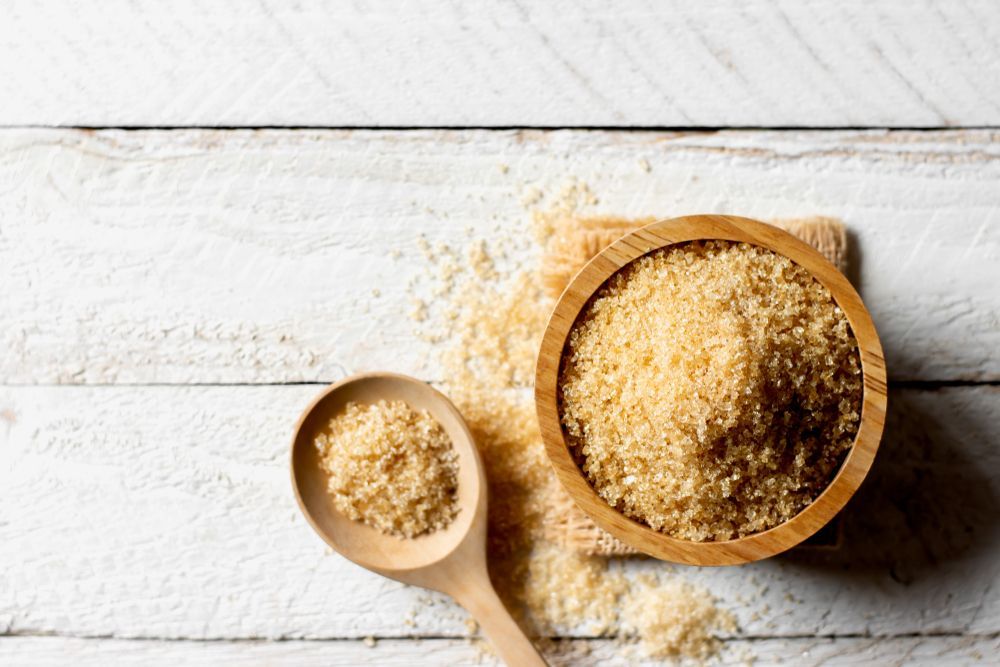 Maple sugar with light brown coloring sits in a rustic wooden bowl -What is Maple Sugar, Maple Sugar vs Maple Syrup