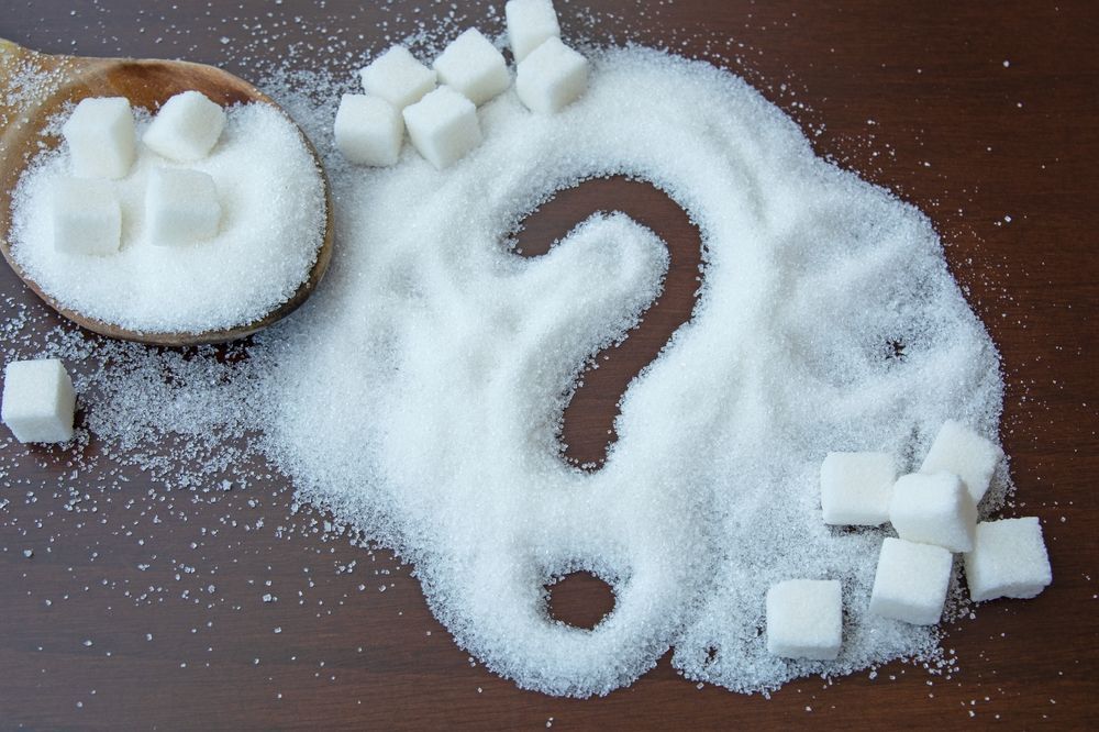 A question mark is drawn on a pile of sugar
