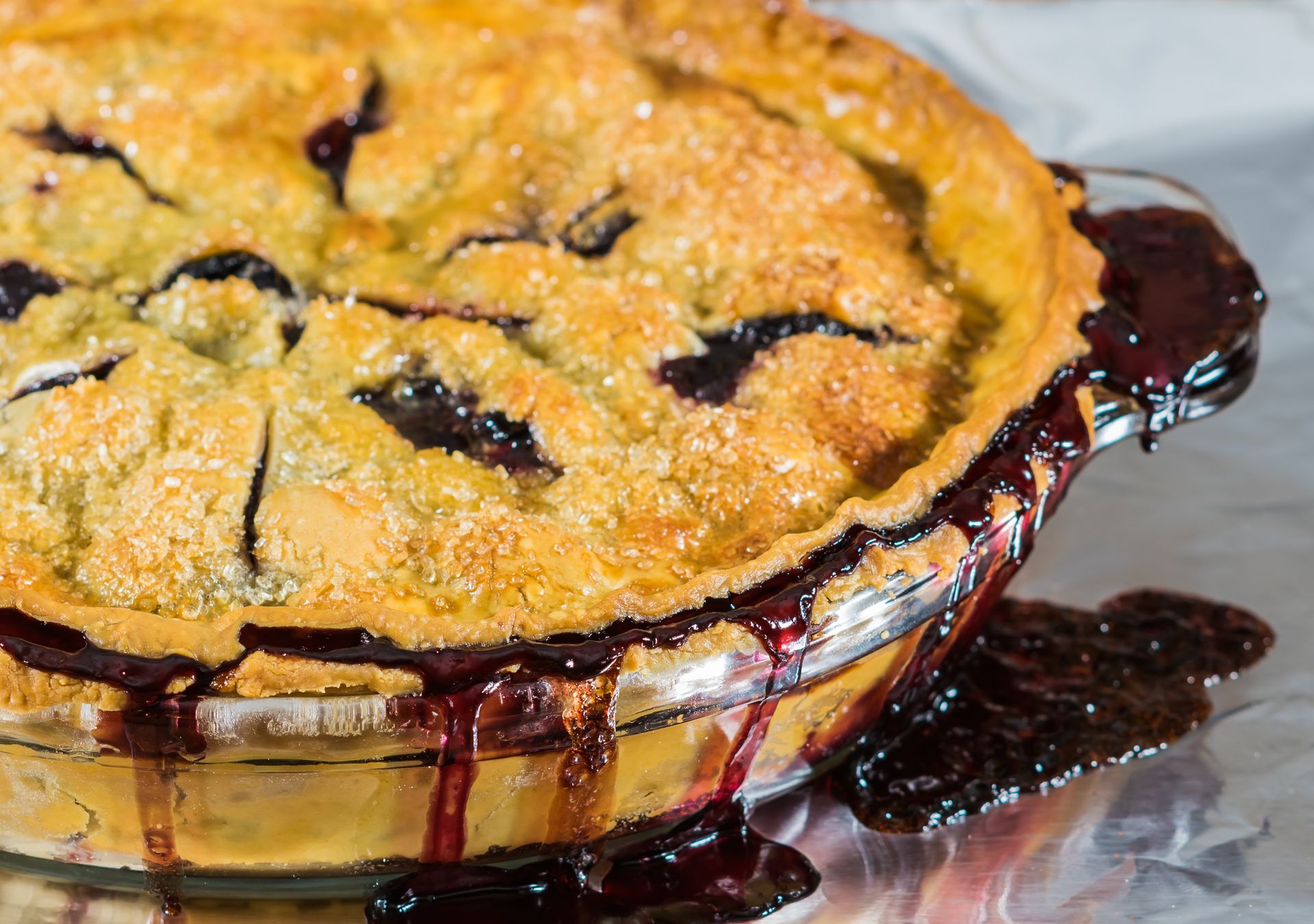 sanding sugar ontop of a freshly baked blueberry pie
