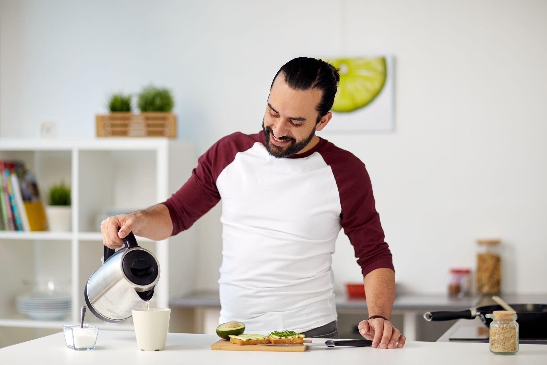 A man adds hot water to his morning tea | he is exploring Types of Sugar Alternatives and Sweeteners