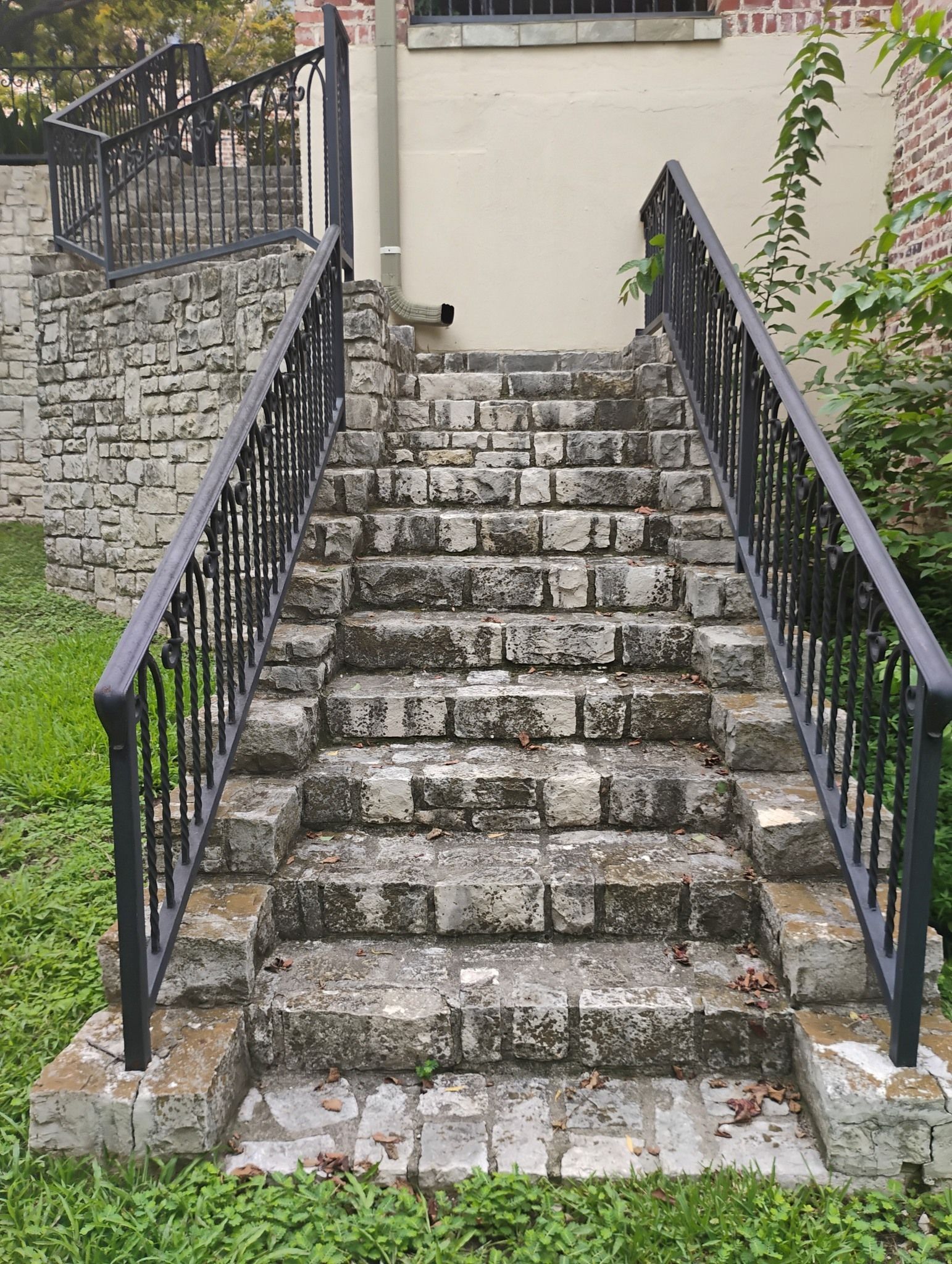Steep stone staircase with black railings leading up to a building entrance
