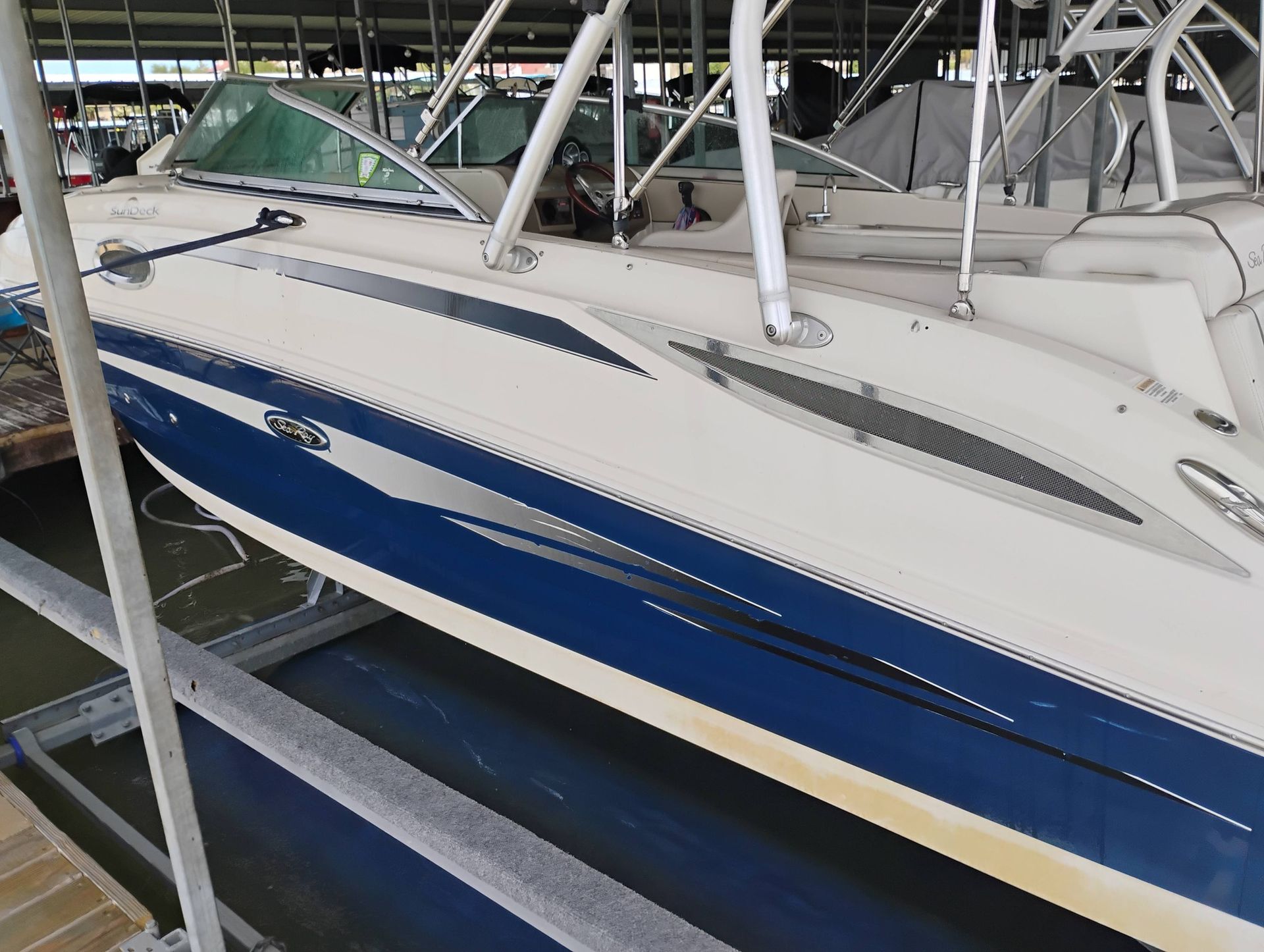 Blue-and-white sailboat hulls stored in a marina or boatyard