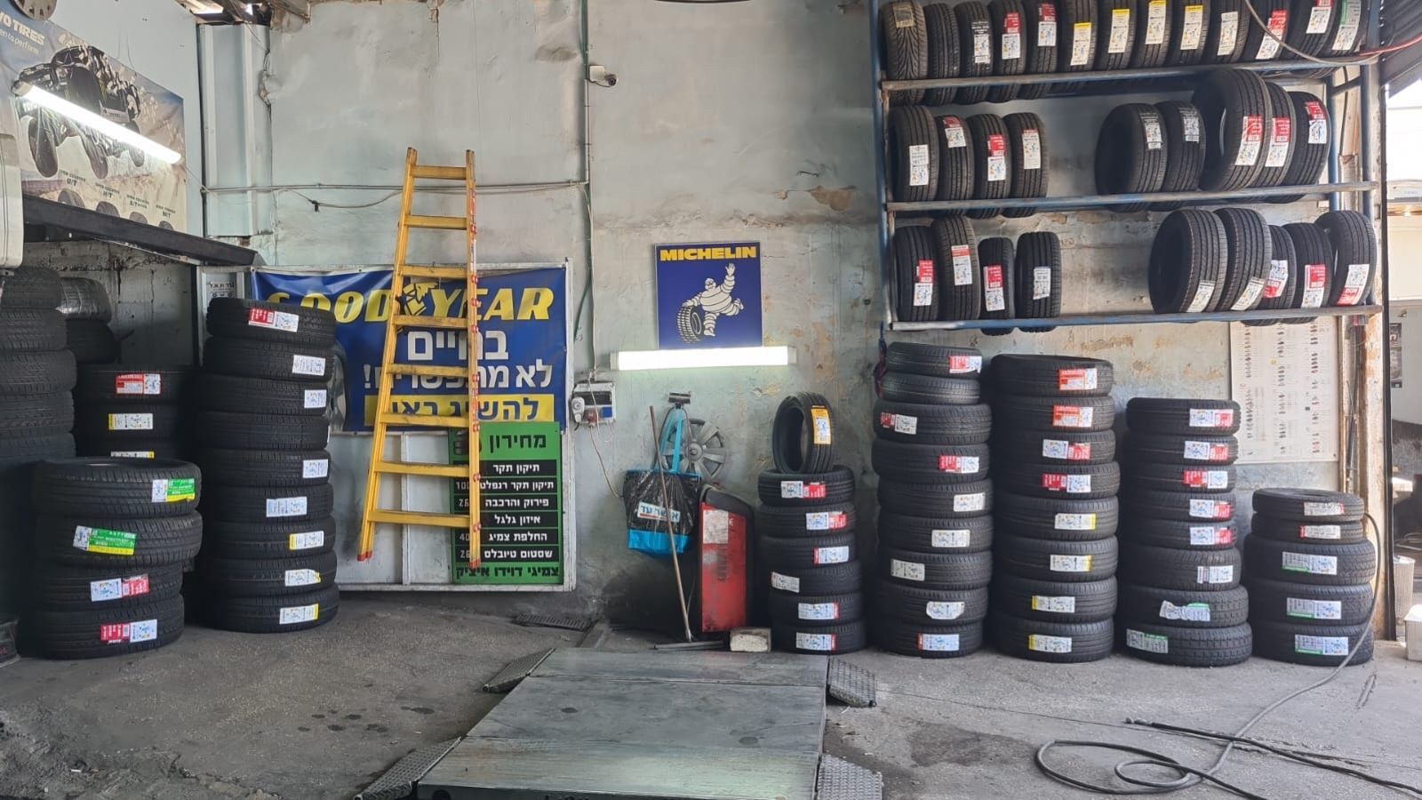 אזור העבודה המקצועי בתוך פנצ'ריה בירושלים, הכולל מלאי צמיגים מסודר וציוד