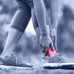 a person is holding their ankle in pain from Sports Injury
