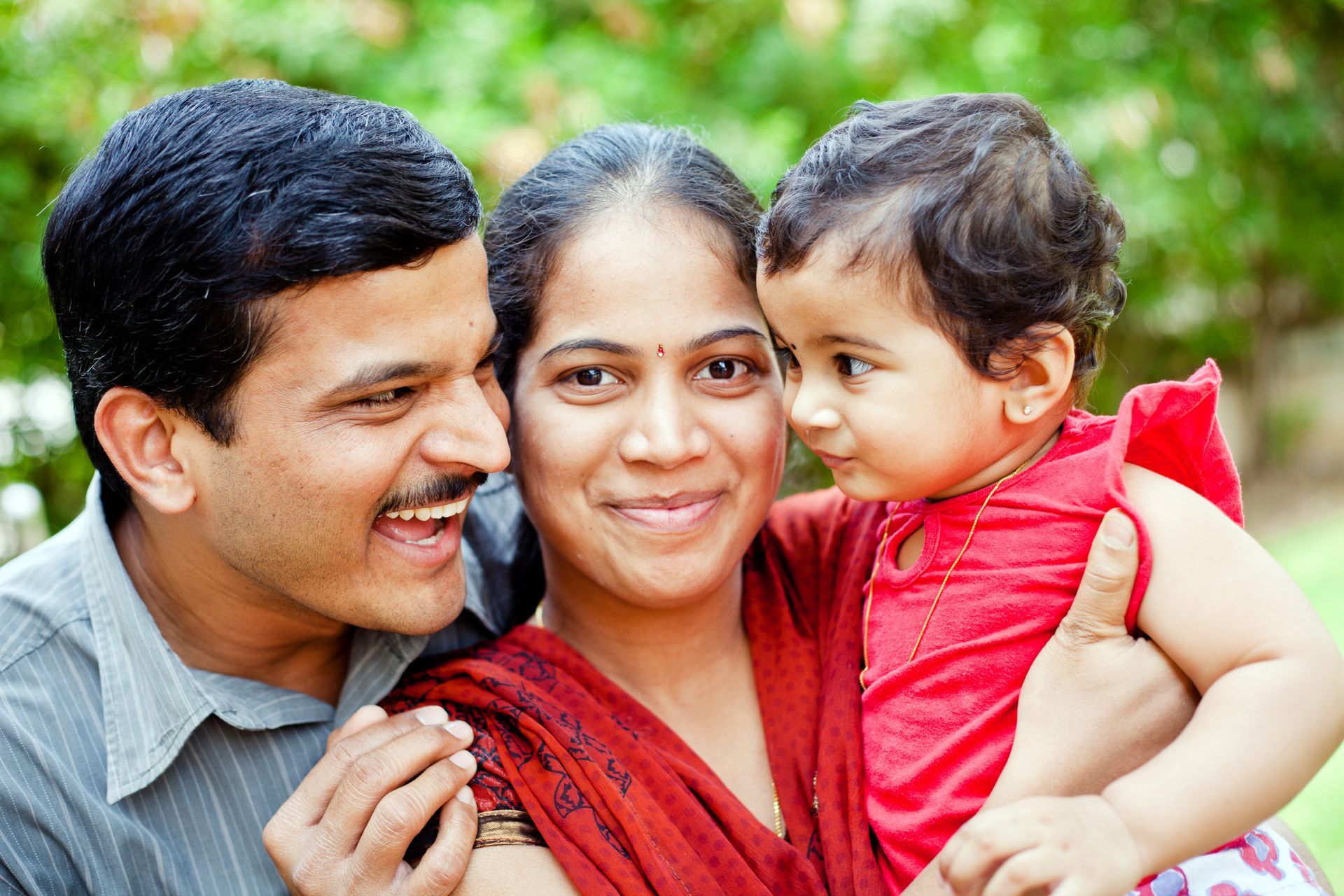 A man and woman are holding a baby in their arms.
