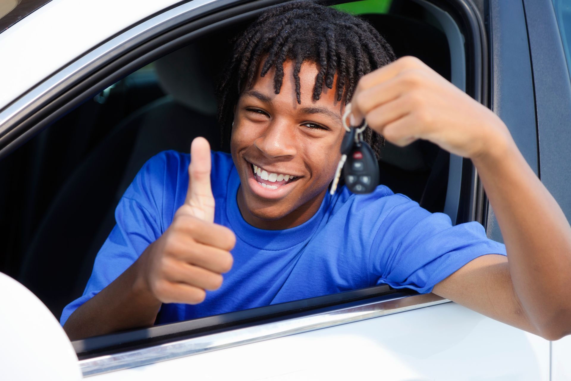 Teen driver in car holding a set of car keys