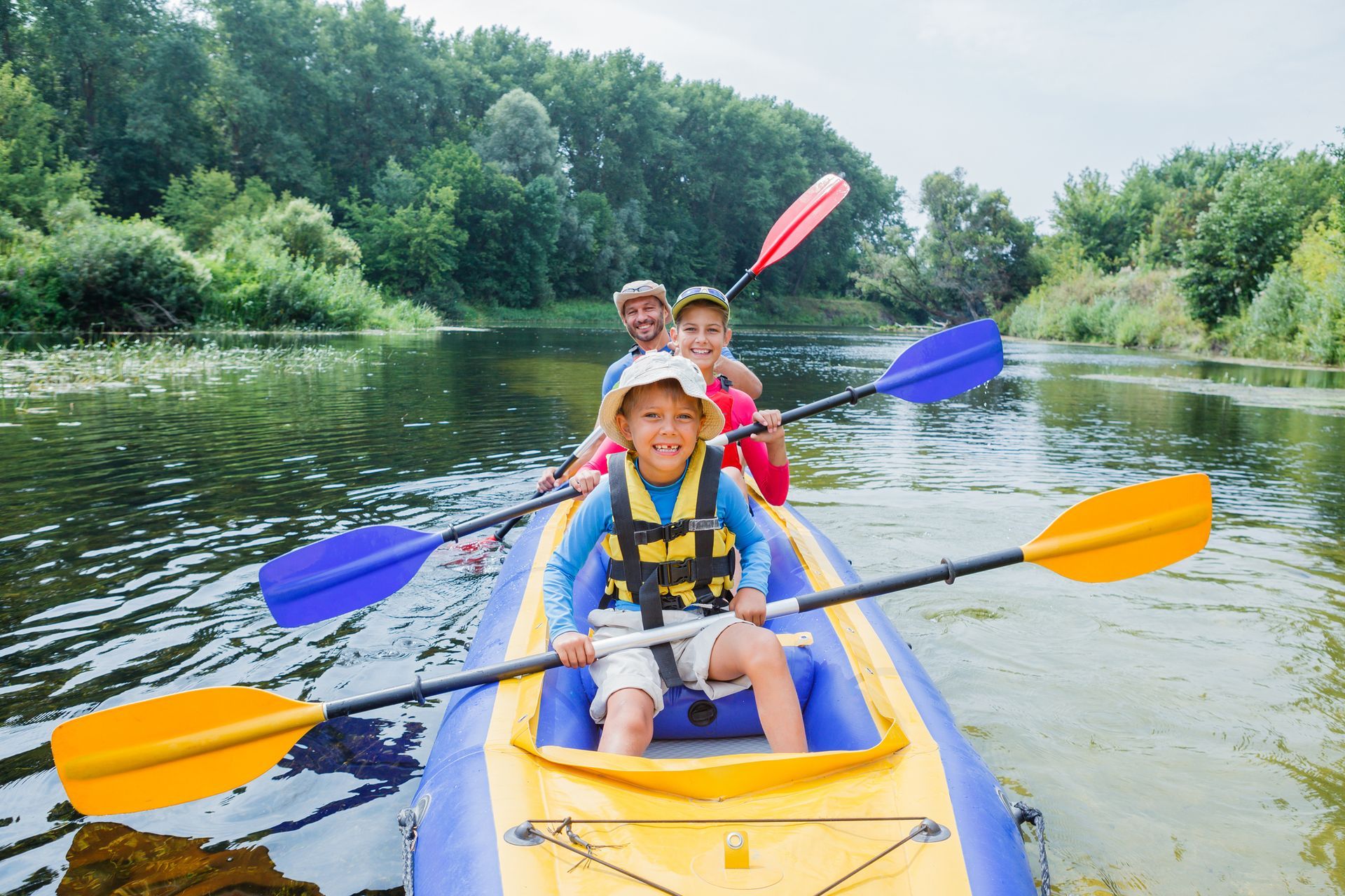 A family is paddling a kayak down a river.