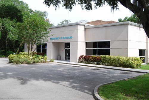 A white building with a blue sign that says health and services