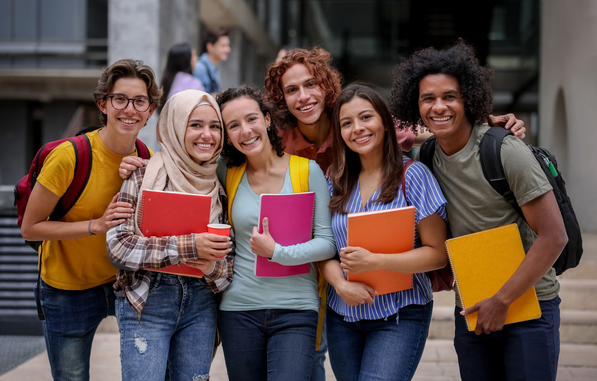 A group of young people are posing for a picture while holding books.