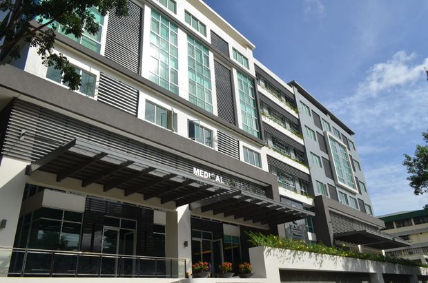 Modern gray and white multi-story building with glass windows and a sign that says