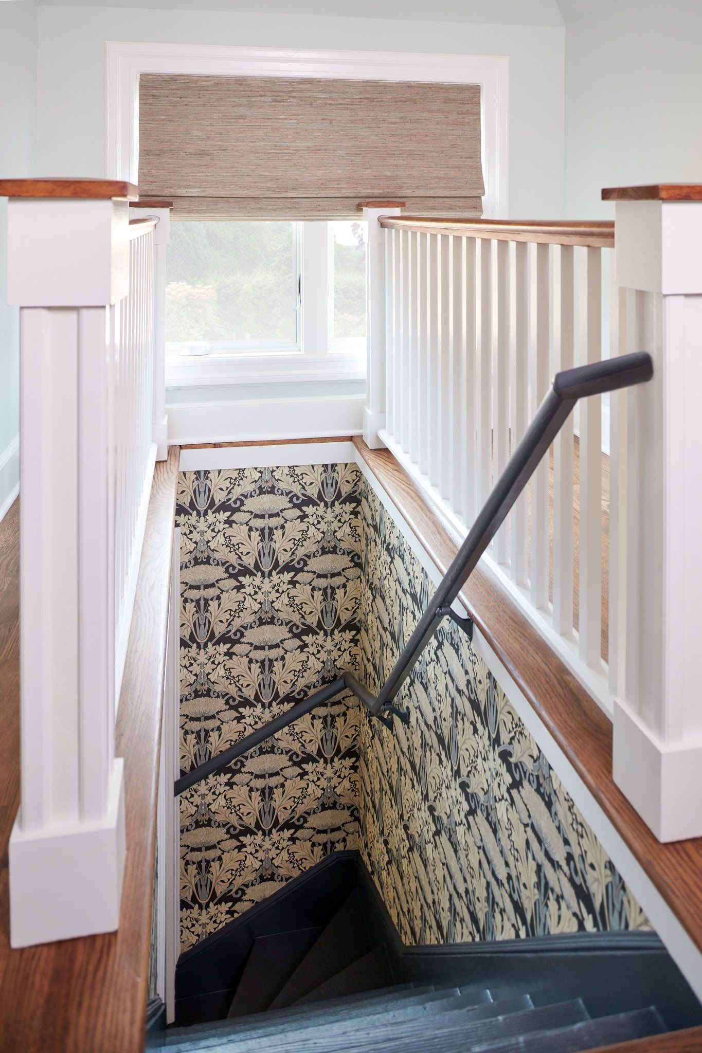 A staircase with a railing and a window in a house.
