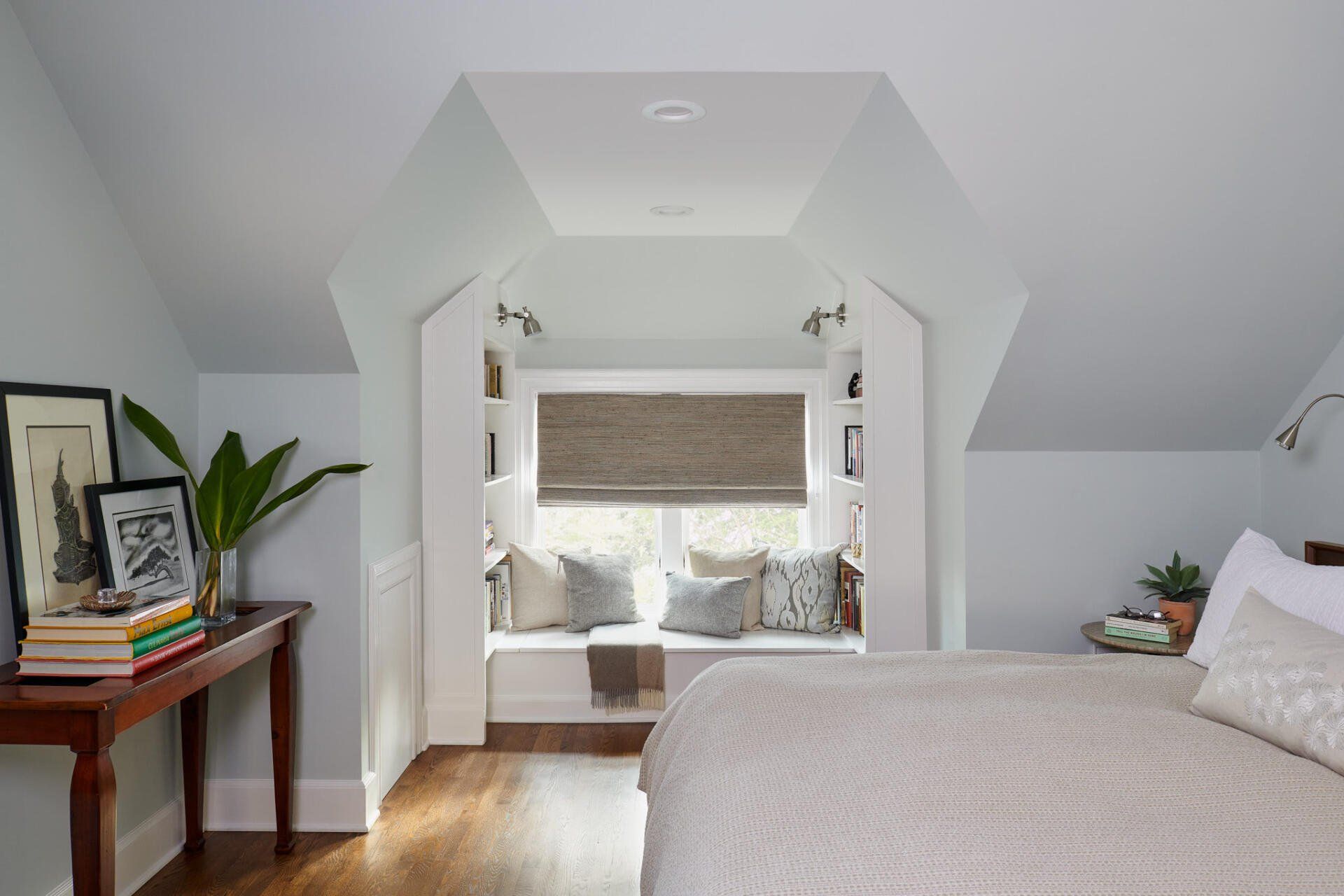 A bedroom with a bed and a window seat.