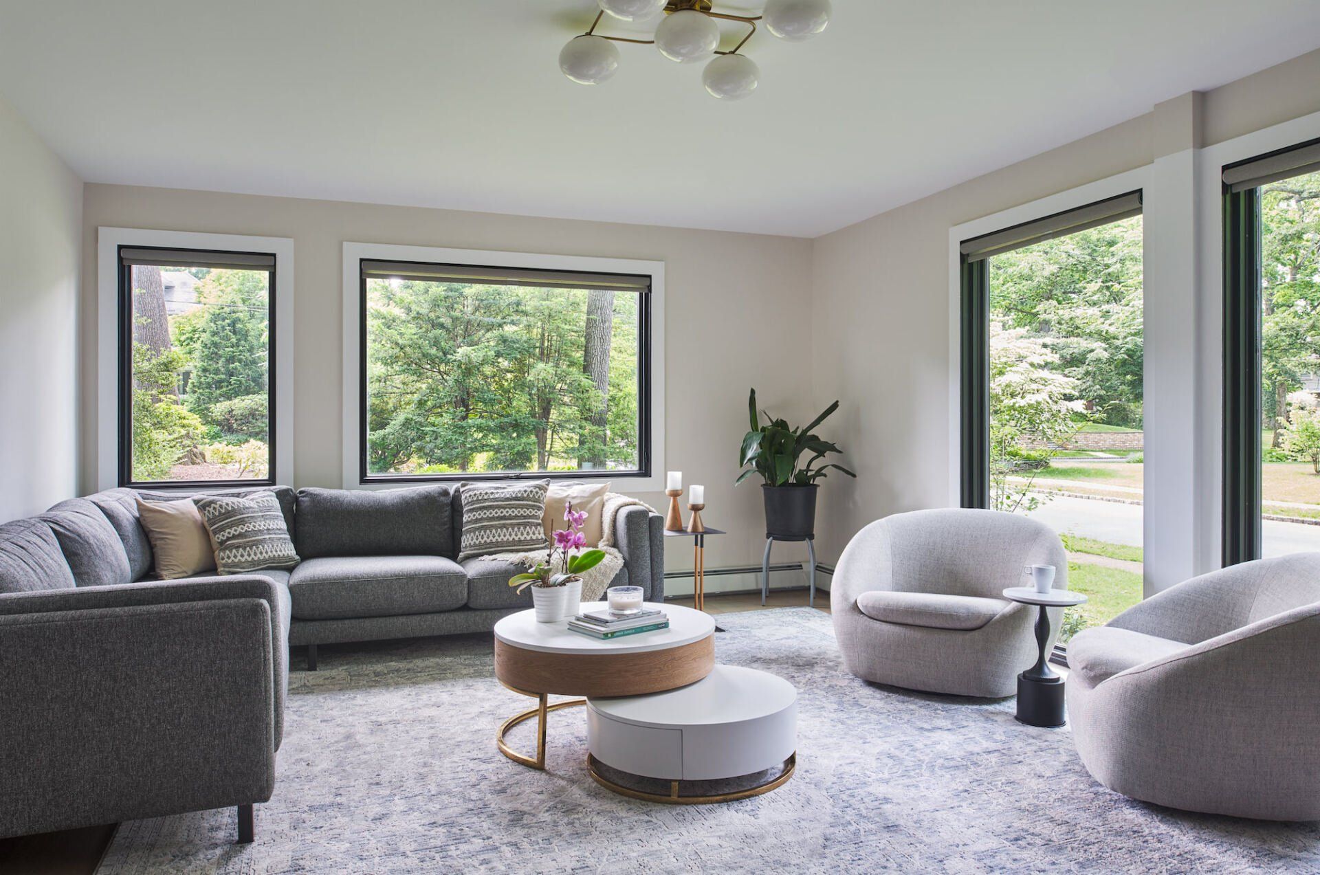 A living room with a couch , chairs , and a coffee table.