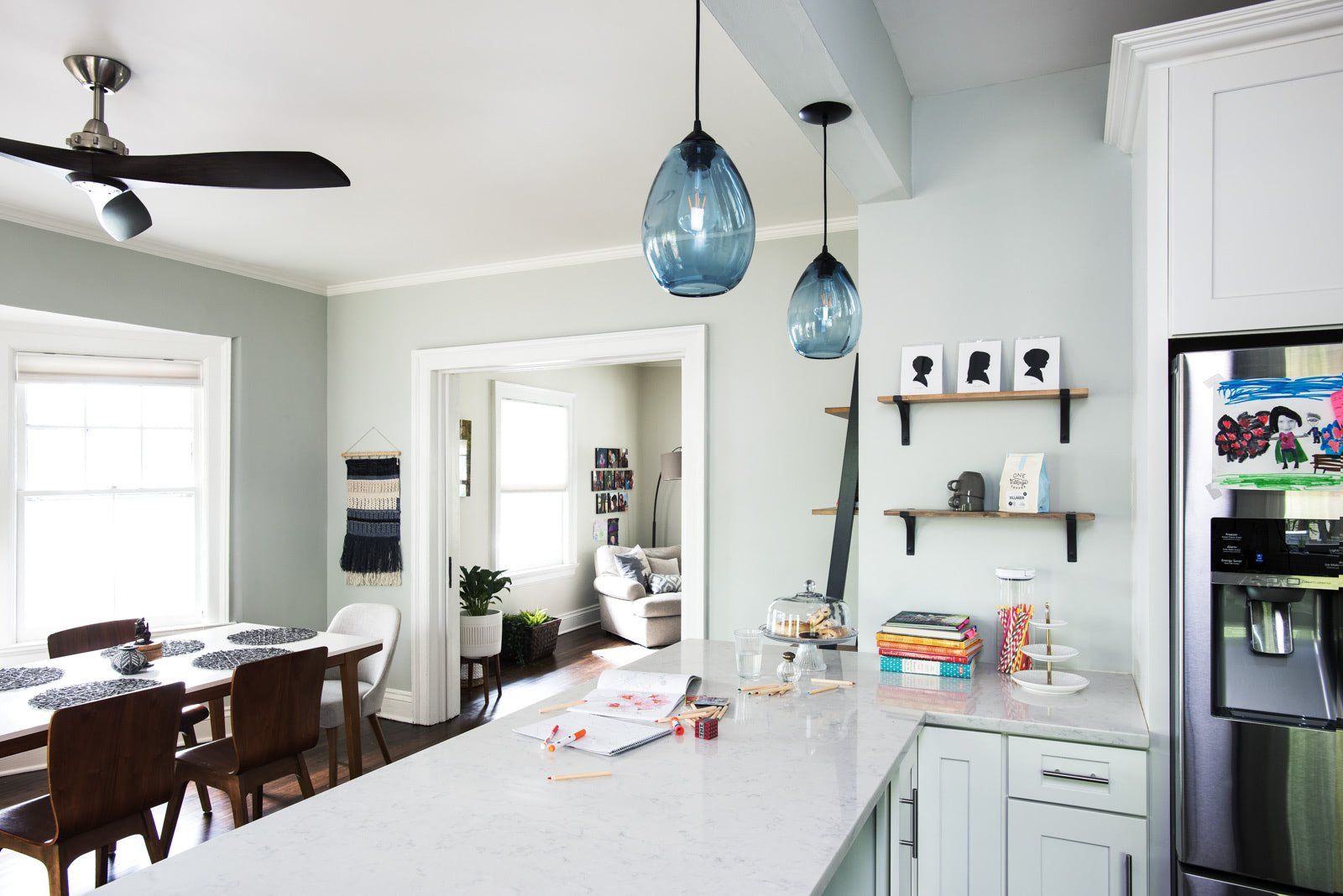 A kitchen with white cabinets and a stainless steel refrigerator