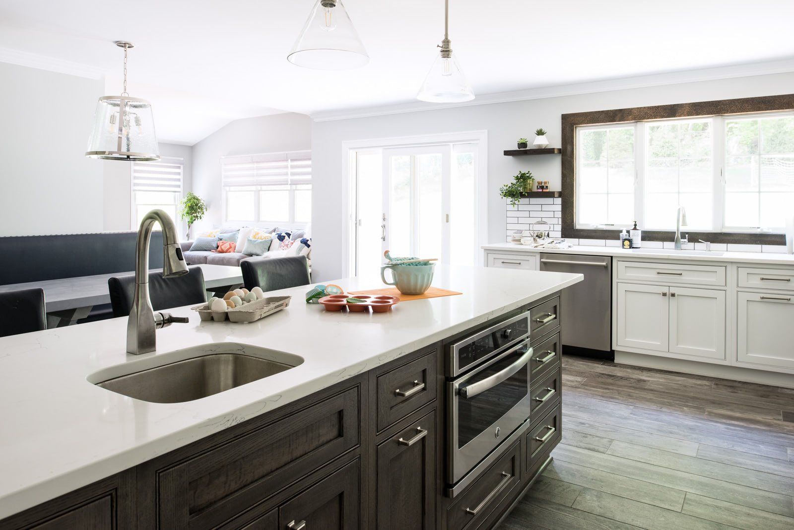 A kitchen with a large island , sink , oven , and dishwasher.