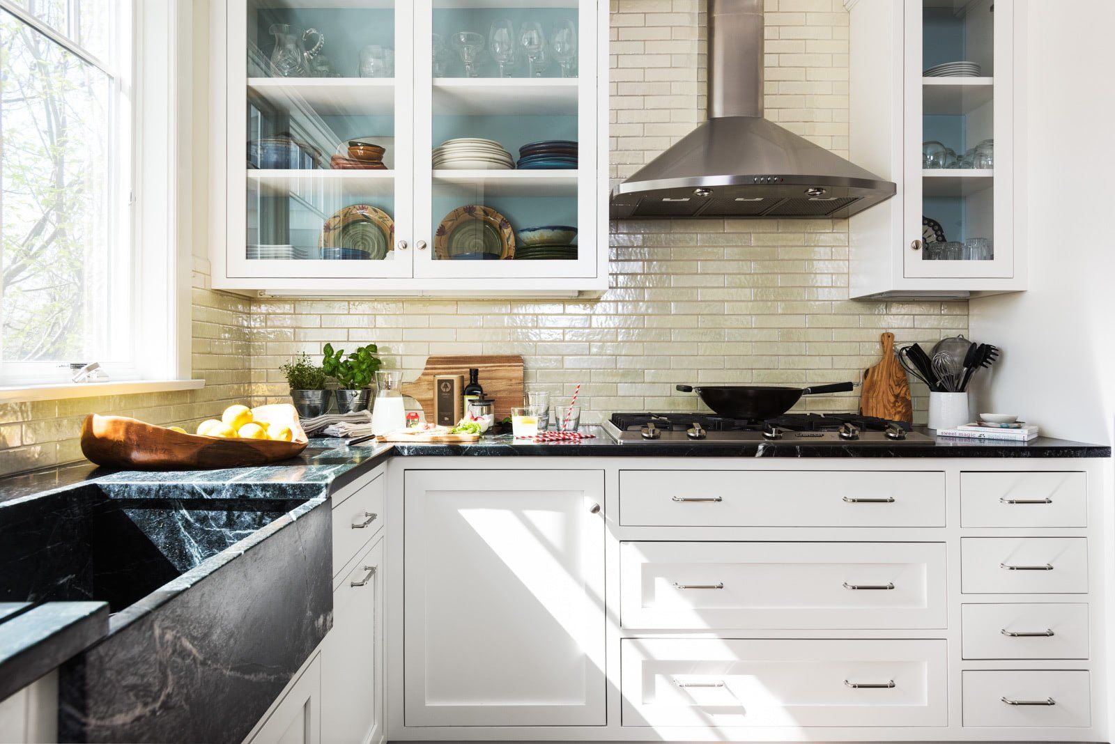 A kitchen with white cabinets and a black sink