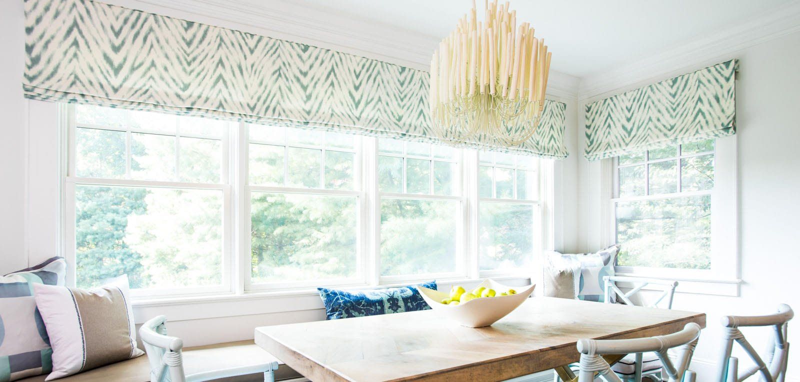 A dining room with a table and chairs and a window seat.