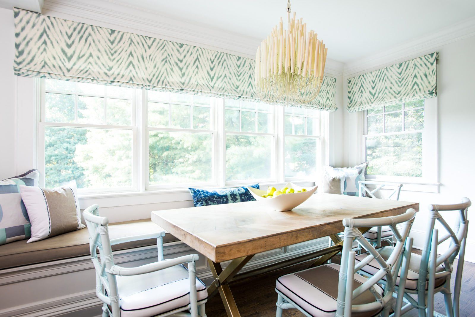 A dining room with a table and chairs and a window seat.