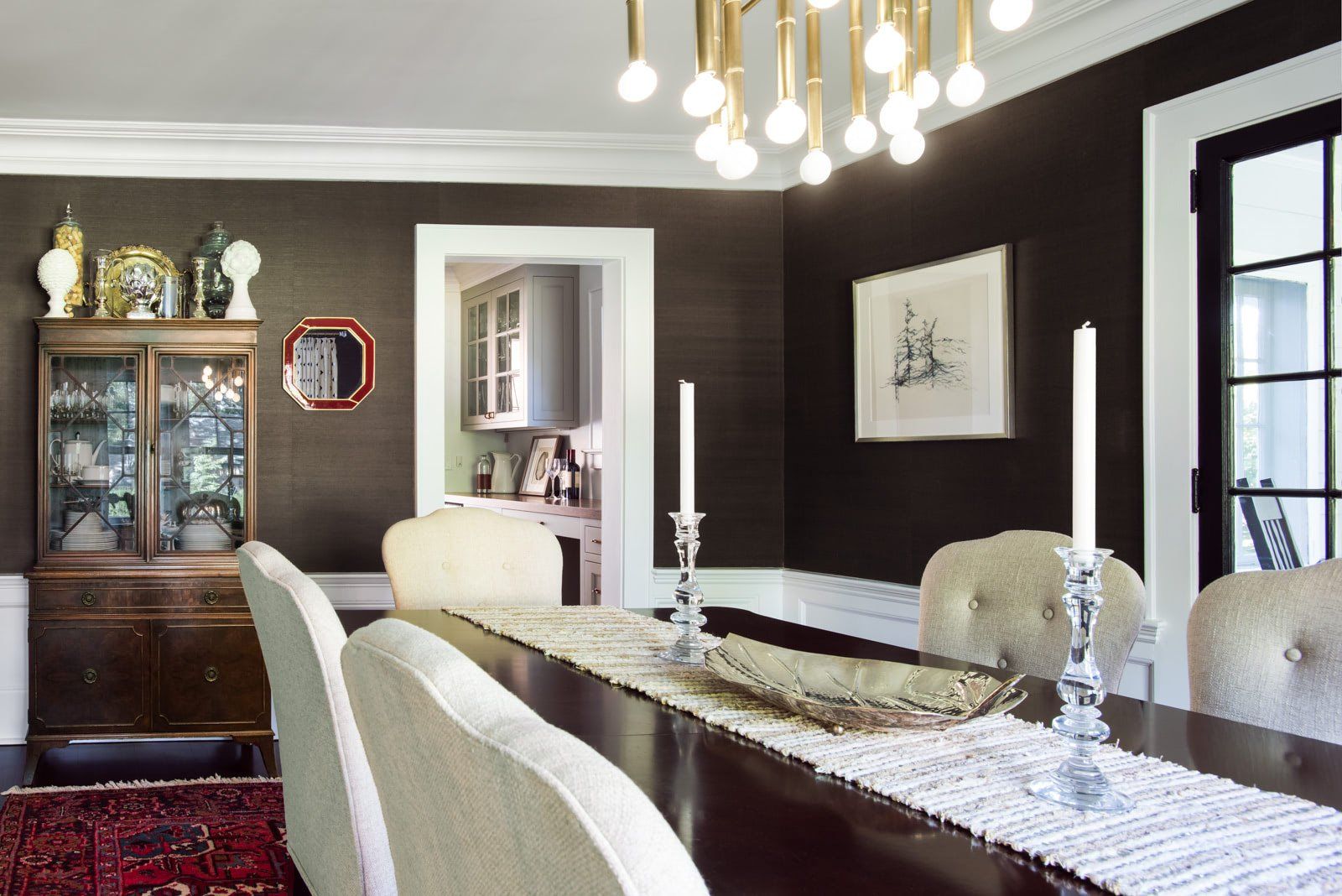 A dining room with a long table and chairs and a chandelier.