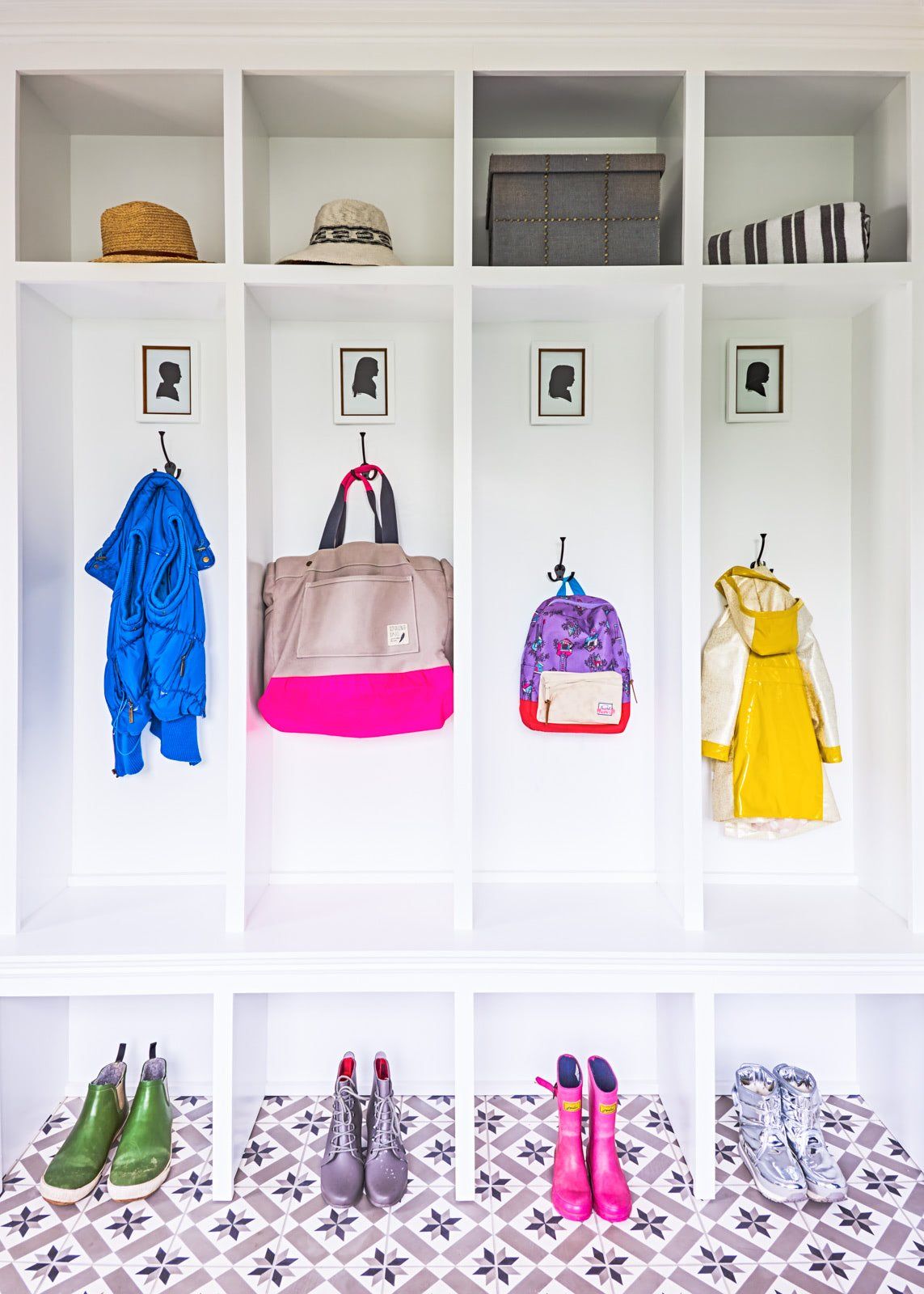 A locker with clothes , bags , and boots hanging on the wall.