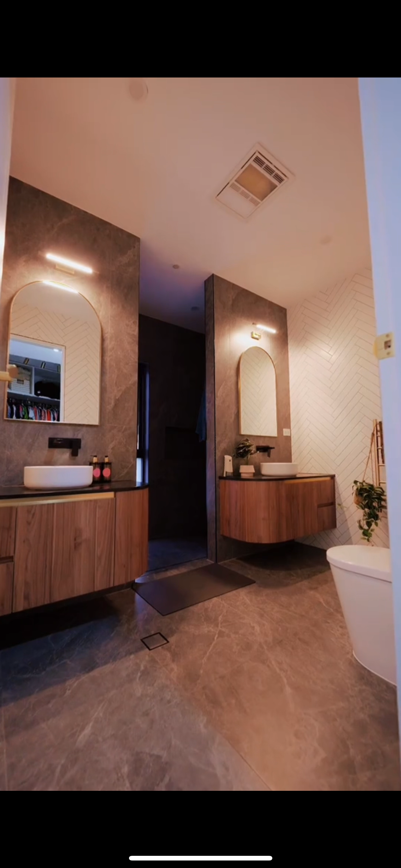 A bathroom with two sinks , a toilet , and a mirror.