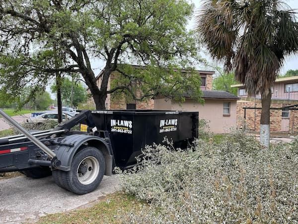 A dumpster is parked in front of a house.