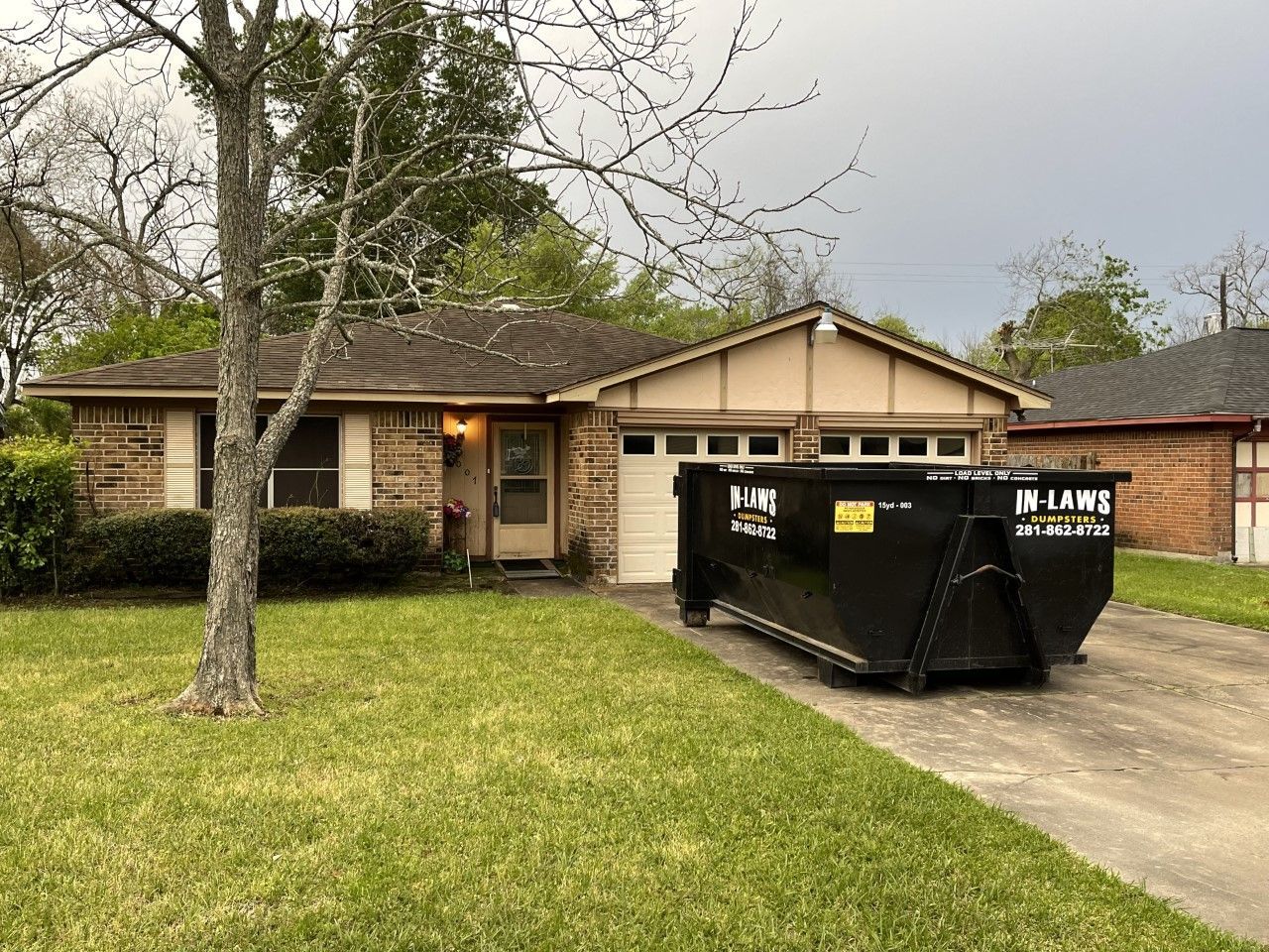 A dumpster is parked in front of a house.
