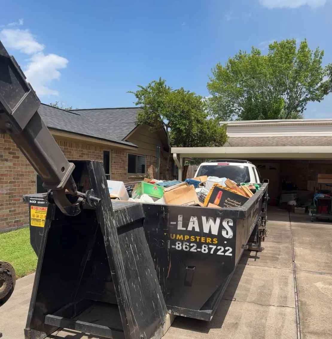 Debris being loaded into an In-Laws roll-off dumpster in Houston