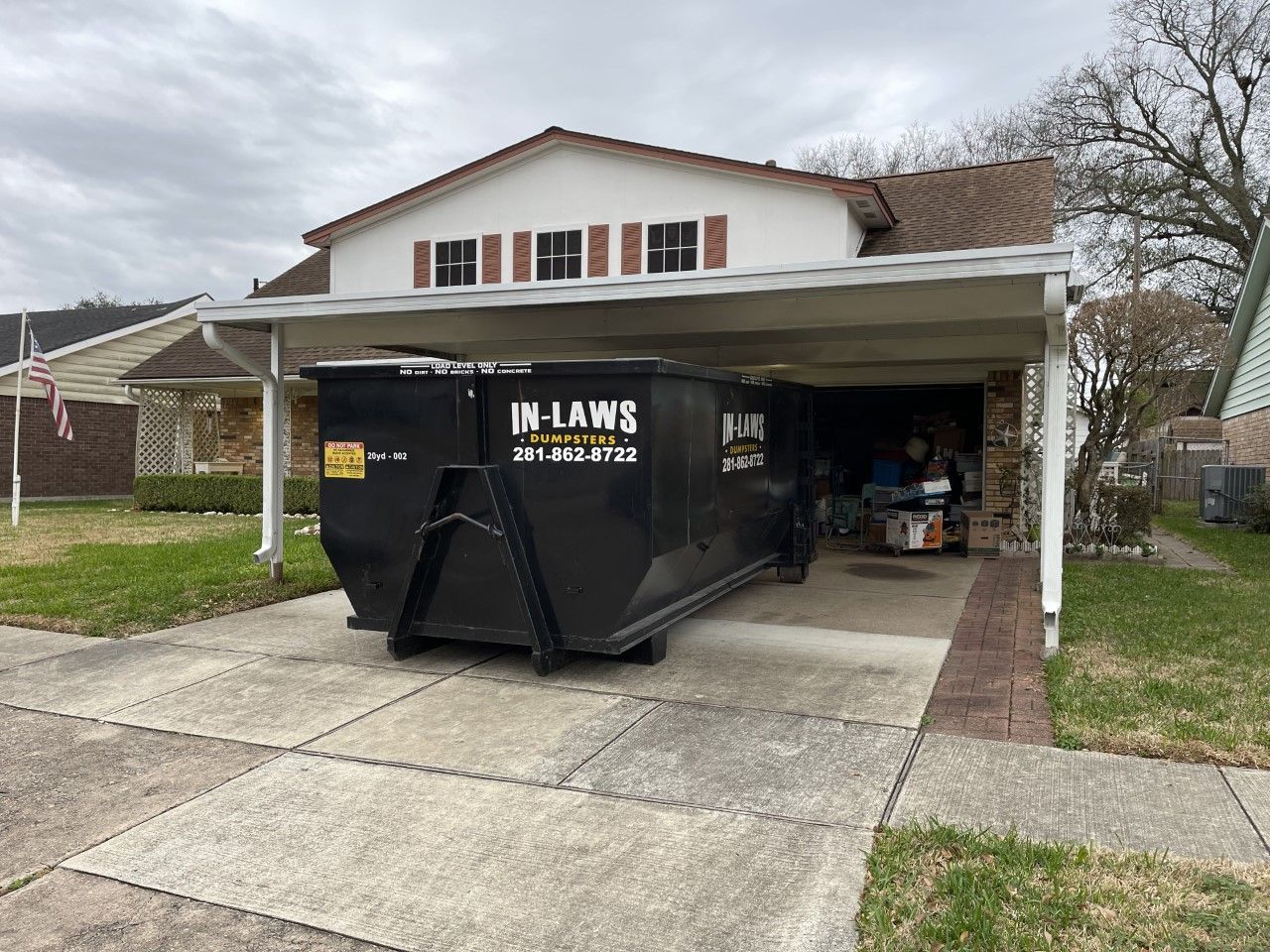 A dumpster is parked in front of a house.