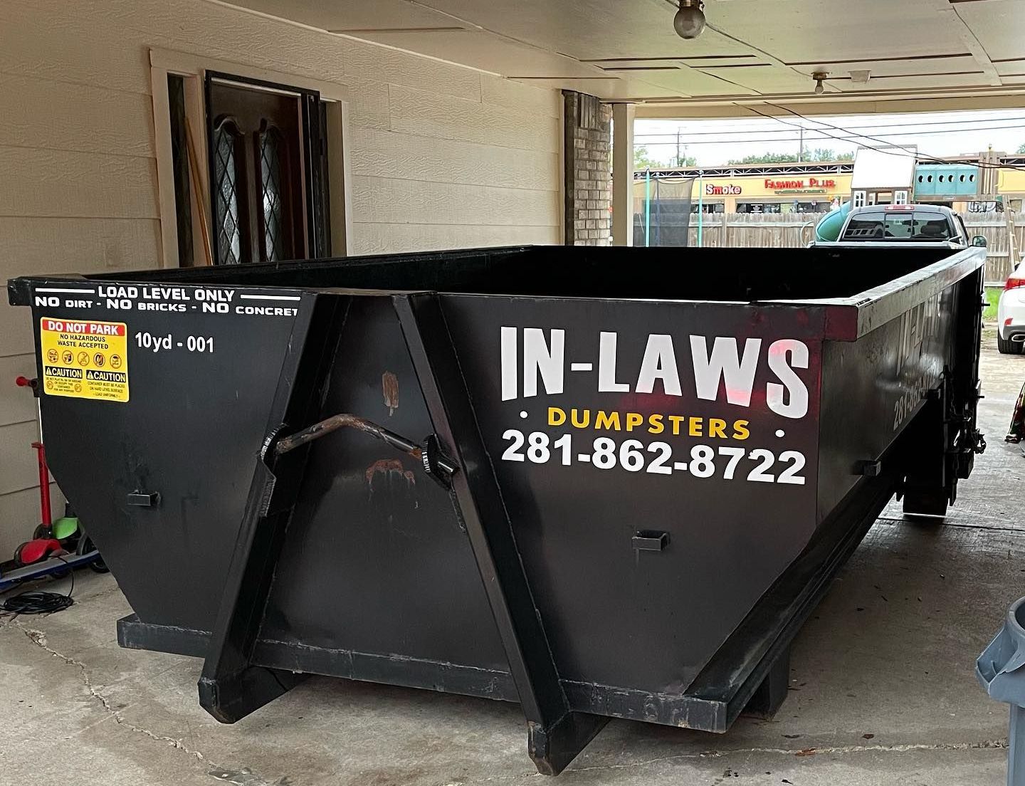 A dumpster for in-laws dumpsters is parked in front of a building.