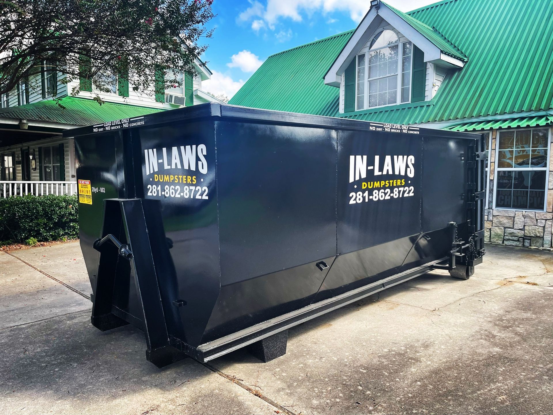 A photo of a dumpster rental from In-Law's Services assisting in moving preparation with a homeowner