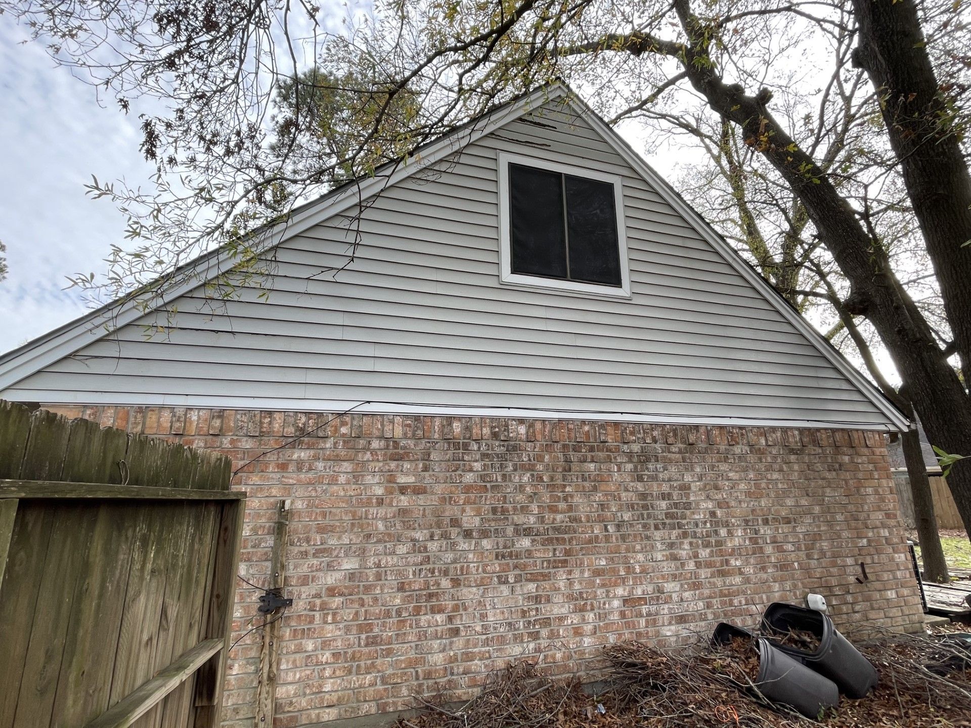 A brick house with a white roof and a window.
