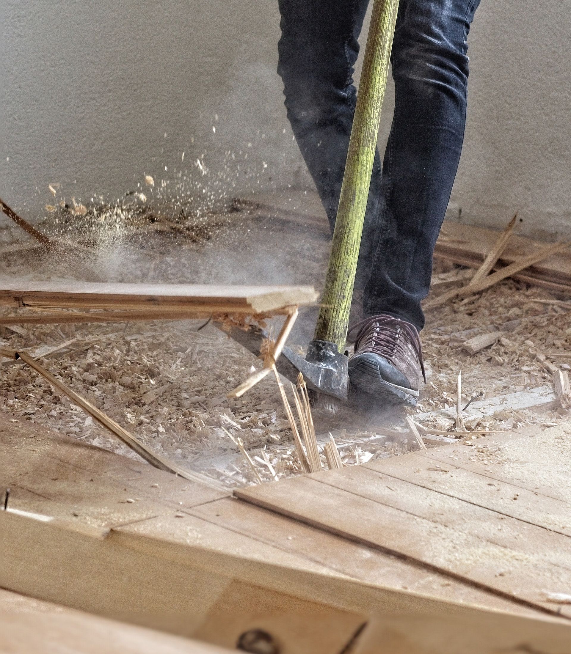 A person is cutting a piece of wood with a green stick